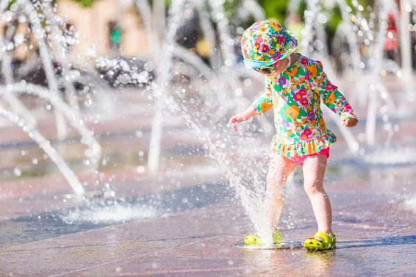 Kleinkind spielt mit Springbrunnen — Stockfoto