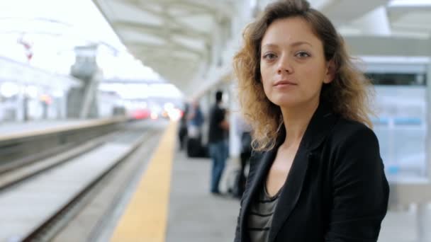 Женщина с чемоданом на платформе на вокзале . — стоковое видео