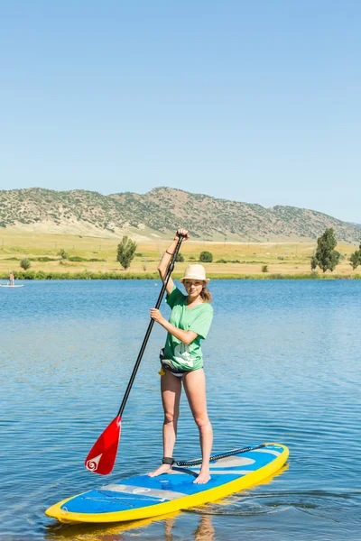 젊은 여자 배우 paddleboard 하는 방법 — 스톡 사진