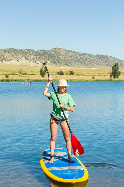 젊은 여자 배우 paddleboard 하는 방법 — 스톡 사진