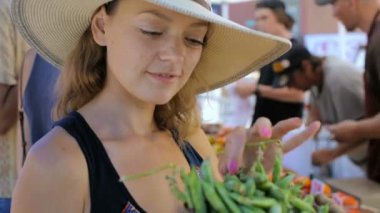  Genç kadın yerel çiftçi pazarda alışveriş.