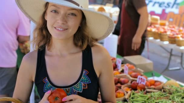 年轻女子在当地的农民市场购物. — 图库视频影像