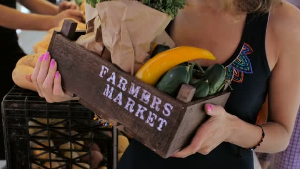 Jonge vrouw winkelen bij de lokale boerenmarkt. — Stockvideo