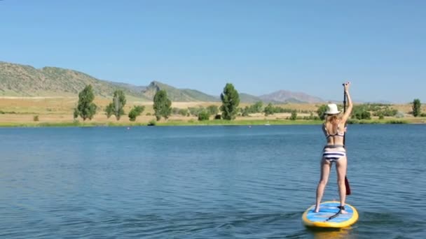 Νεαρή γυναίκα μαθαίνοντας πώς να paddleboard — Αρχείο Βίντεο