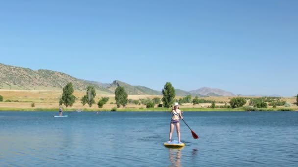 Fiatal nő, tanulás, hogyan kell paddleboard — Stock videók