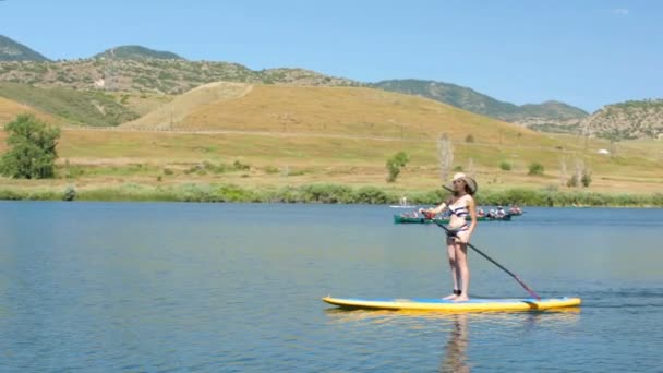 Νεαρή γυναίκα μαθαίνοντας πώς να paddleboard — Αρχείο Βίντεο