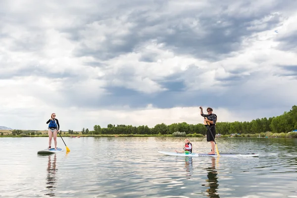 Family paddleboarding on small pond. — Stock Photo, Image
