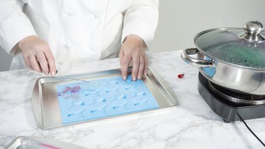 Adım adım. Vanilyalı kekleri süslemek için silikon kalıplı çikolata denizkızı kuyruğu yapıyorum..