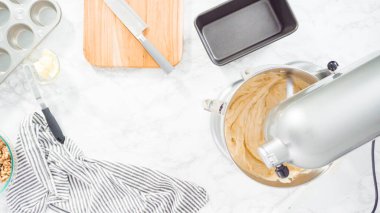 Düz yatıyordu. Adım adım. Muz ekmeği pişirmek için malzemeleri metal karıştırma kabına karıştırıyorum..