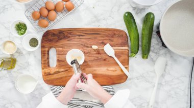 Düz yatıyordu. Adım adım. Sarımsağı ezip kabak keki tarifine ekliyorum..