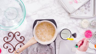 Düz yatıyordu. Adım adım. Küçük elektrikli ocağın üzerinde küçük bir tencerede karamelize şeker.