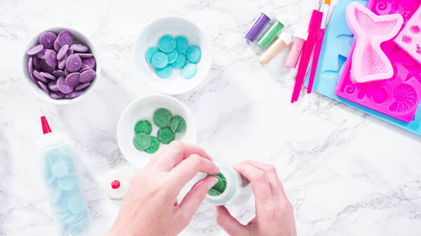 Melting color chocolate chips for making mermaid chocolate molds.
