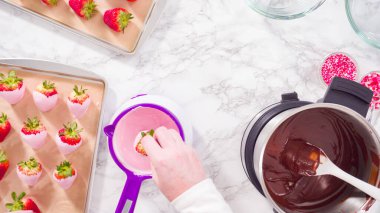 Düz yatıyordu. Adım adım. Çikolata parçacıkları eriyen kaplarda eriyor..