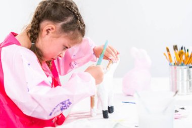 Küçük kız COVID-19 salgınında evde uzaktan öğrenim için sanat projesi üzerinde çalışıyor..