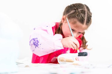 Küçük kız COVID-19 salgınında evde uzaktan öğrenim için sanat projesi üzerinde çalışıyor..