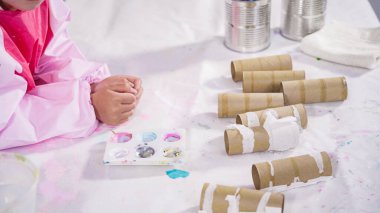 Çocuk kâğıtları. Kağıt hataları yaratmak için boş tuvalet kağıtlarını akrilik boyayla boyamak..