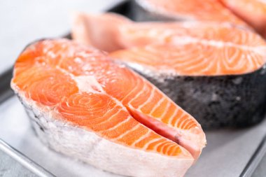 Parşömen kağıdıyla pişirme tepsisinde çiftlik somonu bifteği..