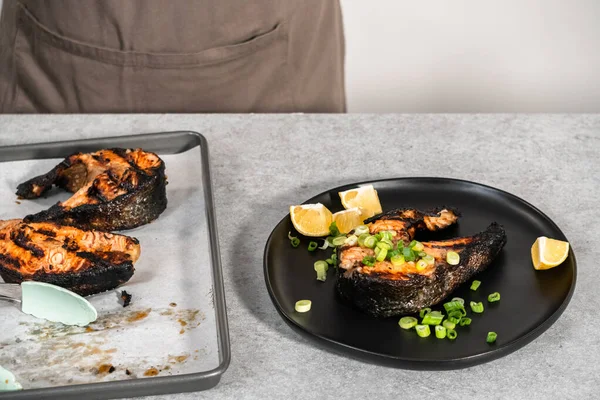 Siyah Tabakta Yeşil Soğanla Süslenmiş Izgara Somon Bifteği — Stok fotoğraf
