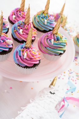 Renkli tereyağlı kremayla süslenmiş tek boynuzlu at kekleri..