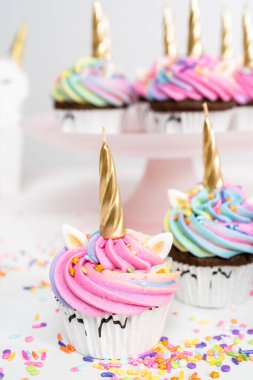 Renkli tereyağlı kremayla süslenmiş tek boynuzlu at kekleri..