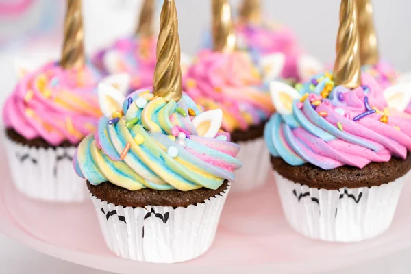 カラフルなバタークリームアイシングとスプリンクルで飾られたユニコーンカップケーキ — ストック写真