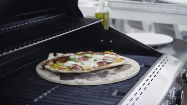 Açık hava ızgarasında pizza pişirmek..
