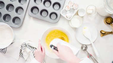 Düz yatıyordu. Adım adım. Vanilyalı kekleri tereyağlı kremayla karıştırıyorum..