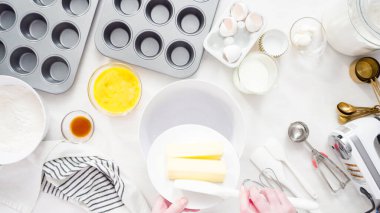 Düz yatıyordu. Adım adım. Vanilyalı kekleri tereyağlı kremayla karıştırıyorum..