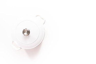 Düz yatıyordu. Beyaz işlemeli dökme demir, beyaz bir arka planda Hollanda fırınıyla kaplı..