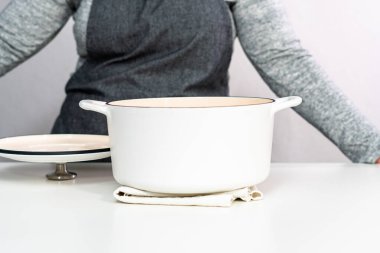 Beyaz işlemeli dökme demir, beyaz bir arka planda Hollanda fırınıyla kaplı..