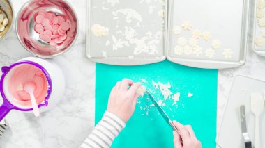 Düz yatıyordu. Adım adım. Fazla çikolatayı, kar taneleri şeklindeki çikolatalardan küçük bir mutfak bıçağıyla budamak..