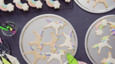 Düz yatıyordu. Adım adım. Tek boynuzlu at şekerli kurabiyelerin üzerine kraliyet kremalı gıda simleri boyamak..