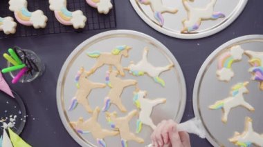 Düz yatıyordu. Adım adım. Tek boynuzlu at şekerli kurabiyelerin üzerine kraliyet kremalı gıda simleri boyamak..