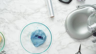 Adım adım. Düz yatıyordu. Kırmızı, beyaz ve mavi fırıldak şekerli kurabiyeler pişirmek için kurabiye hamuruna gıda boyası karıştırıyorum..