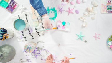 Düz yatıyordu. Adım adım. Süslü deniz kızı Cadılar Bayramı balkabağı yaratmak için akrilik boyalı balkabağı boyamak.