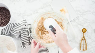 Adım adım. Düz yatıyordu. Çikolata parçacıklı kurabiye yapmak için cam kasede malzemeleri karıştırıyorum..