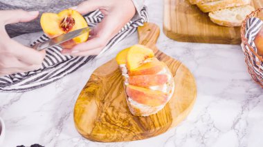 Adım adım. Ciabatta ekmeğinde ricotta ve şeftalili tost yapmak için organik şeftali dilimliyorum..