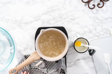 Düz yatıyordu. Ev yapımı lolipop yapmak için tencerede karamelize şeker.