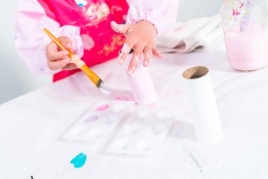 Tuvalet kağıdından tek boynuzlu at yapan küçük bir kız..