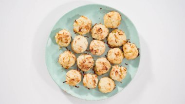 Düz yatıyordu. Yeni pişmiş hindistan cevizli kurabiyeleri servis tabağına koyuyorum..