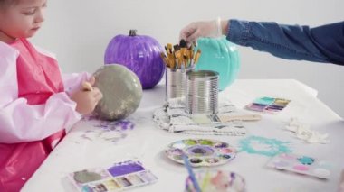 Küçük kız Cadılar Bayramı balkabağını yapay elmaslarla süslüyor. 