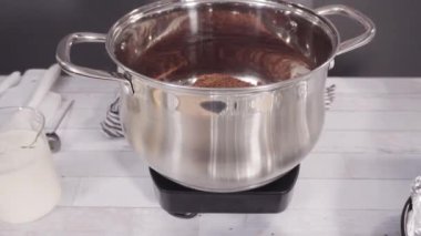 Basit çikolatalı şekerlemeler yapmak için yemek kabındaki malzemeleri karıştırıyorum..