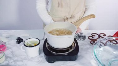 Küçük elektrikli ocağın üzerinde küçük bir tencerede karamelize şeker.