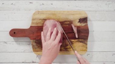 Tahtada bir parça çiğ eti tutan el.