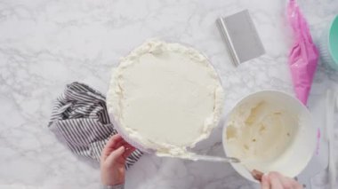 Pembe tereyağlı krema kaplı yuvarlak funfetti kek katmanları.