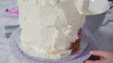 Pembe tereyağlı krema kaplı yuvarlak funfetti kek katmanları.