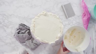 Pembe tereyağlı krema kaplı yuvarlak funfetti kek katmanları.
