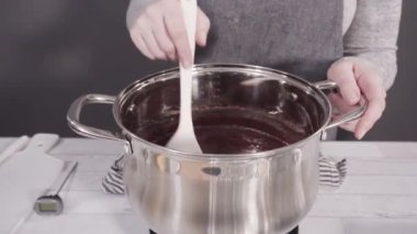 Basit çikolatalı şekerlemeler yapmak için yemek kabındaki malzemeleri karıştırıyorum..