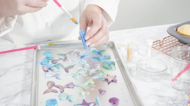 Adım adım. Vanilyalı kekleri süslemek için silikon kalıplı çikolata denizkızı kuyruğu yapıyorum..