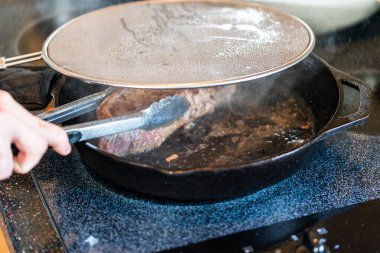 Elektrikli fırının üstünde kızgın demir tavayla New York bifteği kızartıyorum..